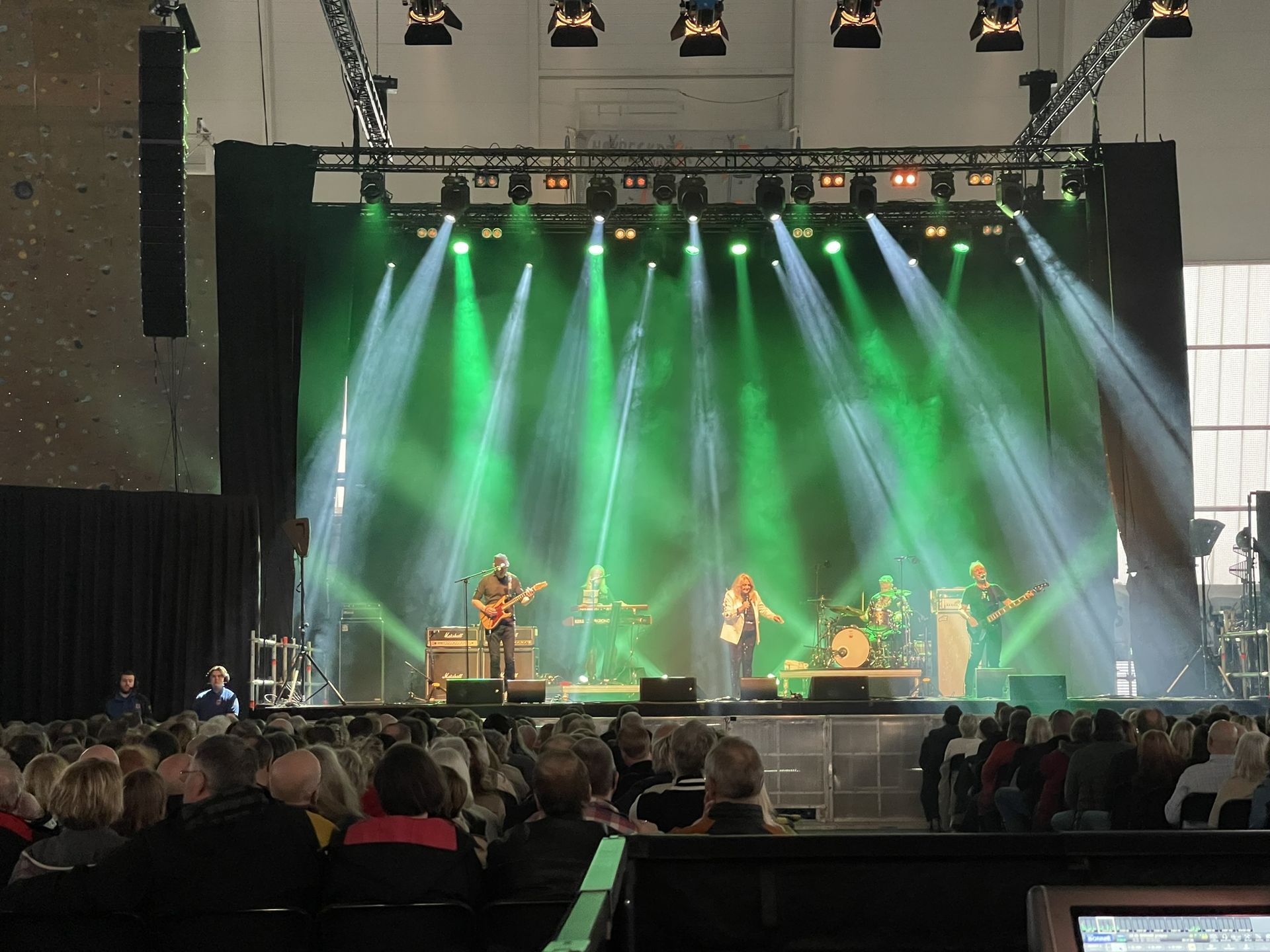 Konsert med publikum, band og grønt scenelys
