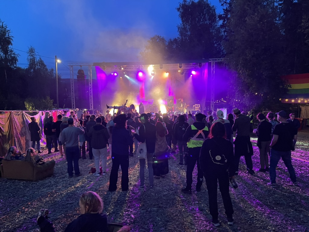 Festivalpublikum og scenelys i skumringen