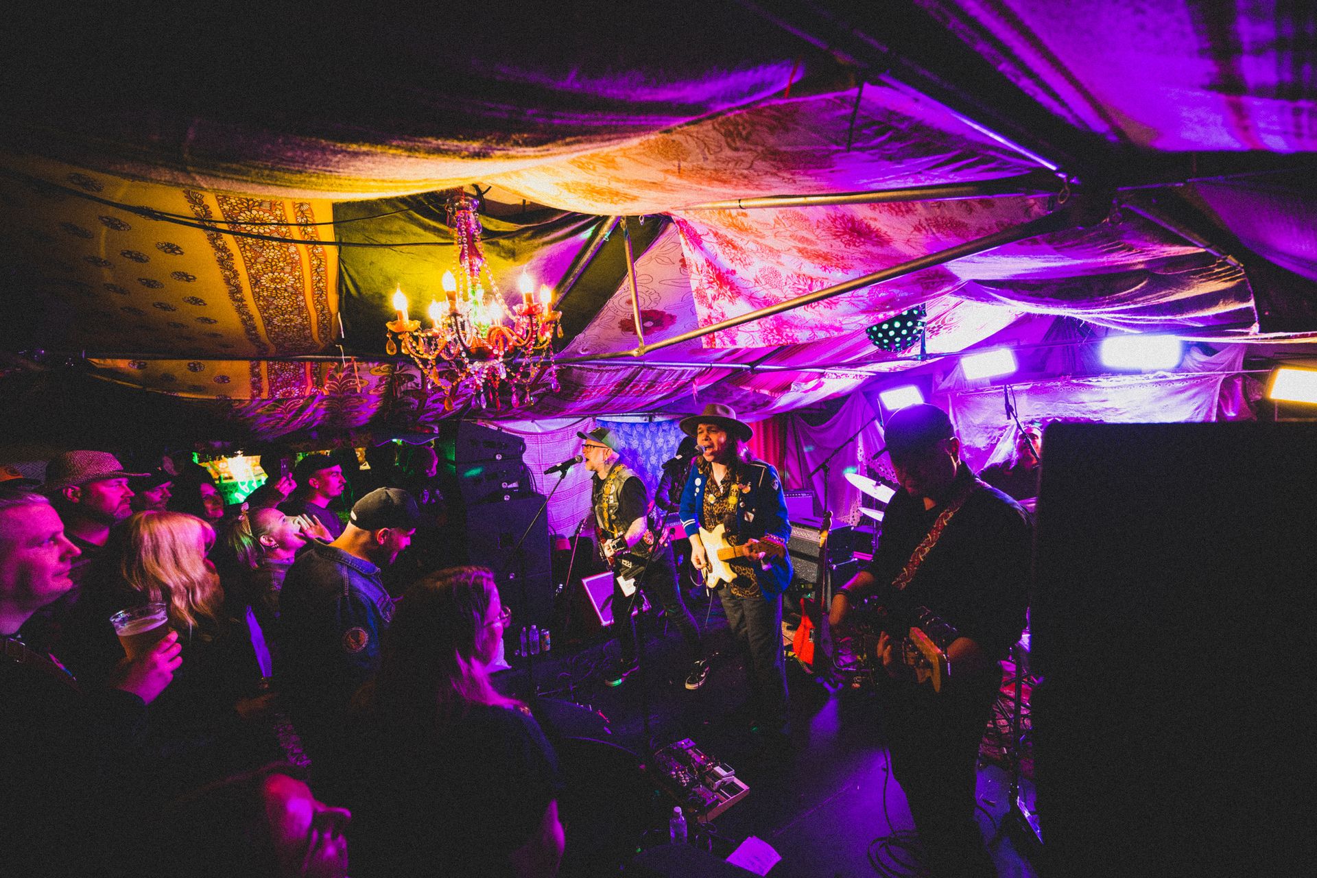 Band og publikum tett sammen på en teltkonsert med lilla scenelys